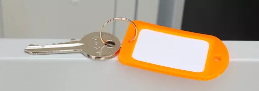 Orange Kunststoff-Schlüsselanhänger mit weißem blanko Etikett